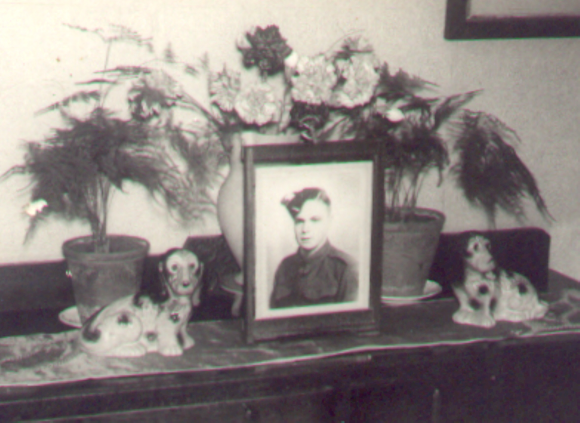 Archive image of framed photograph of Sydney on sideboard surrounded by flowers.