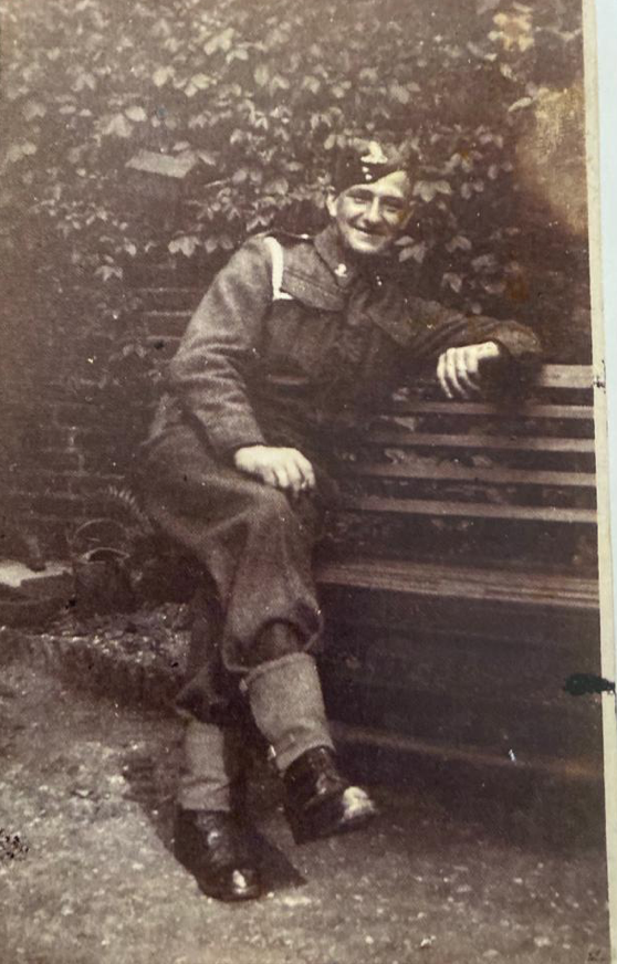 Thomas Warby in uniform sitting outside on a bench