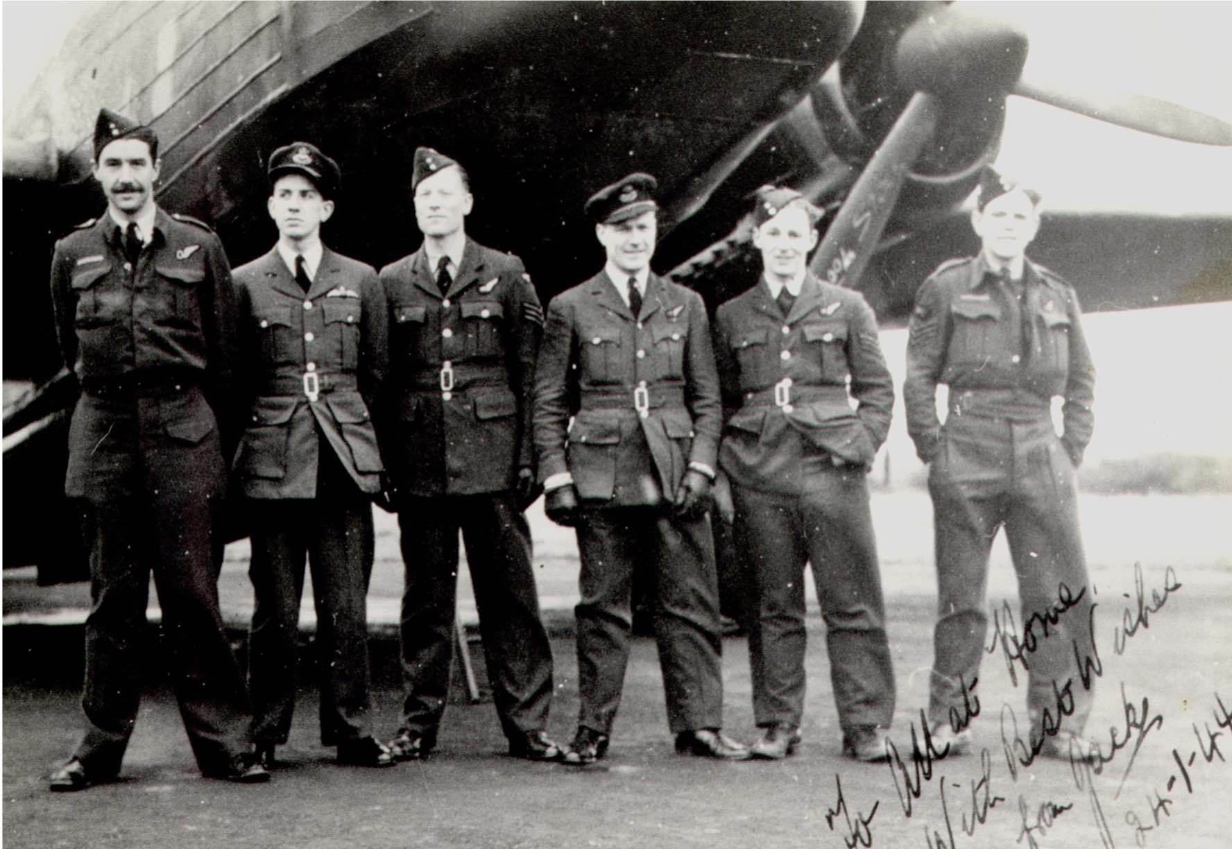 The photograph shows Jack, second from the left on a bomber conversion course prior to converting to the Lancaster. The aircraft is a Wellington bomber and several of the aircrew joined up with Jack on 115 Sqn. Extreme left is his observer. The photo is signed 'All at home, with best wishes from Jack. 24.1.44.' 