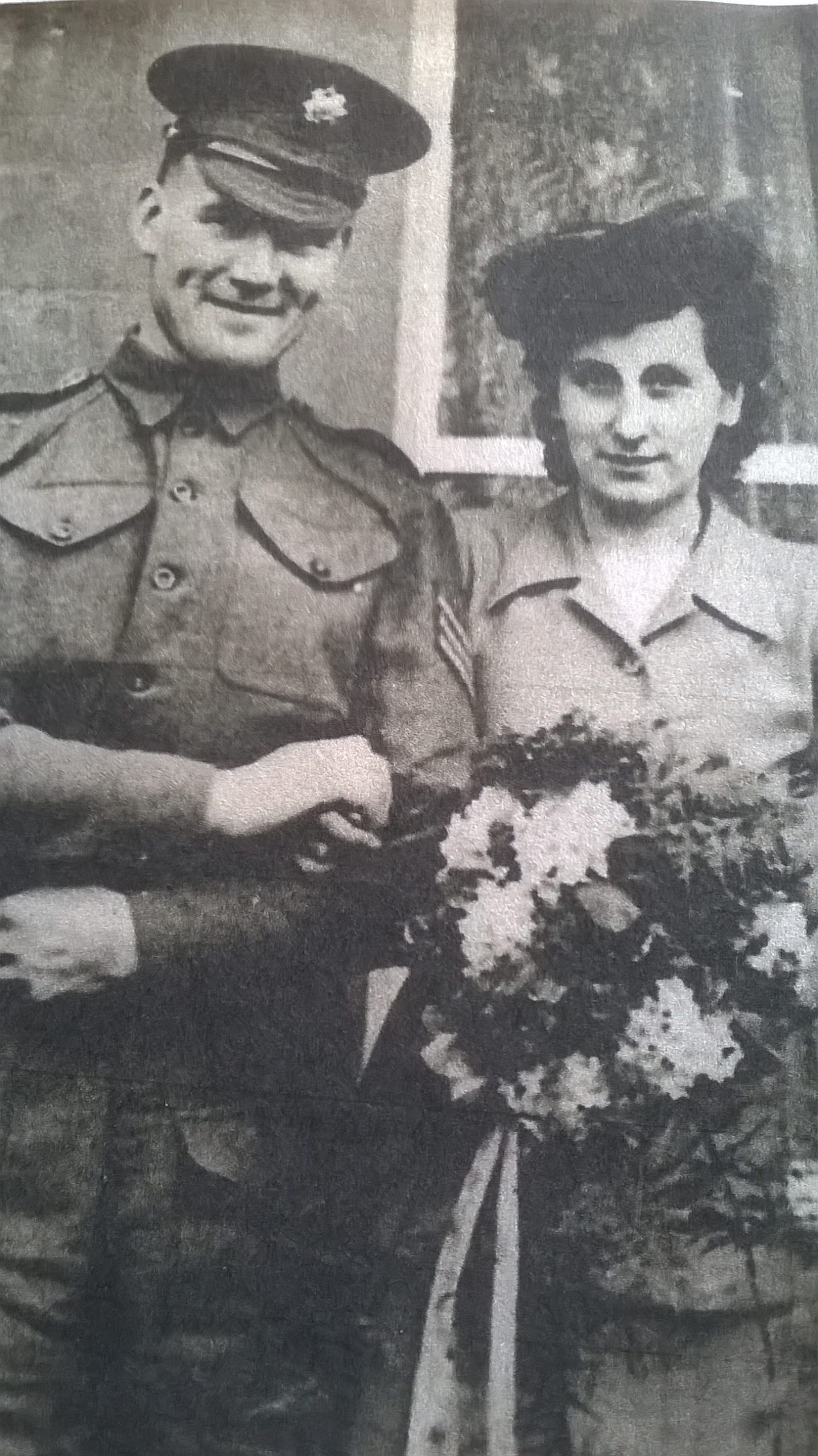 Andrew and Prue pictured on their wedding day. Andrew in uniform and Prue holding a bouquet of flowers.